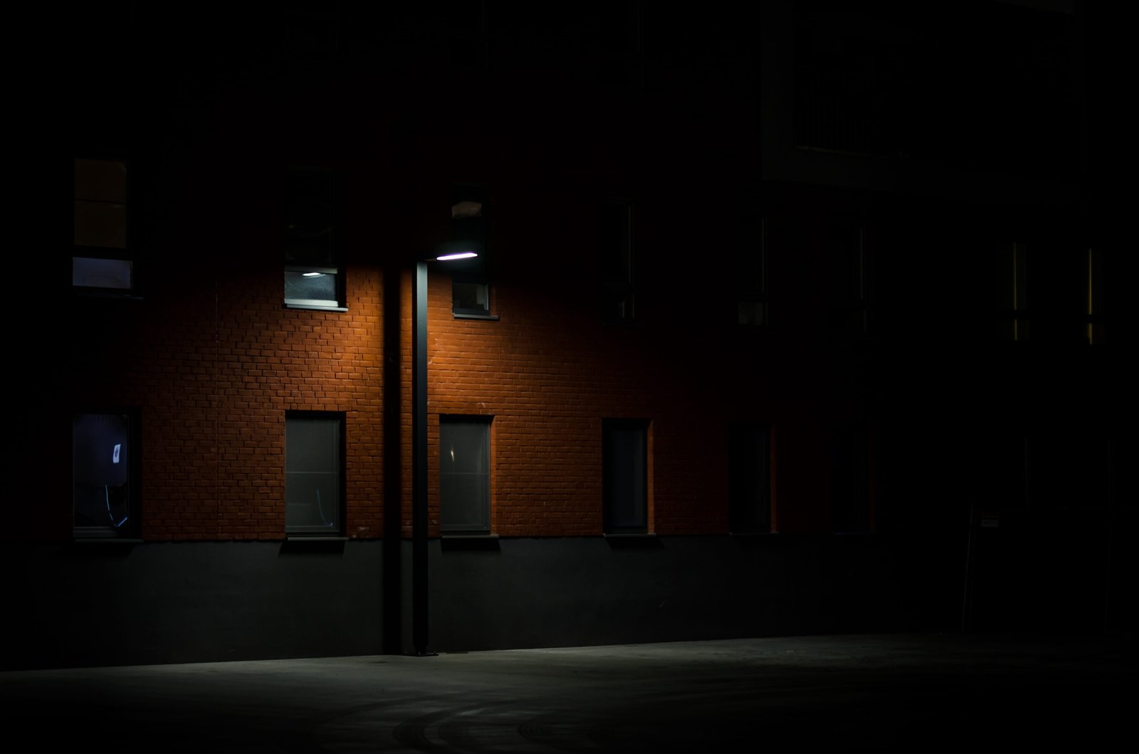 black light post near wall street on brown wooden commercial building during nighttime 2k 4k