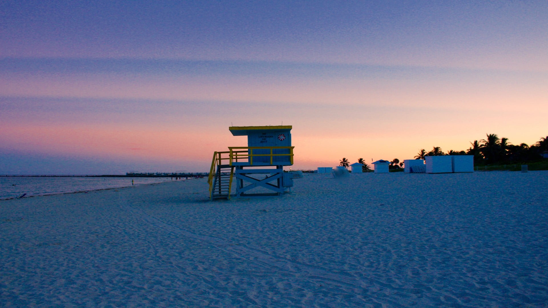 grey and yellow lifeguard house sand beach water sky hut 2k