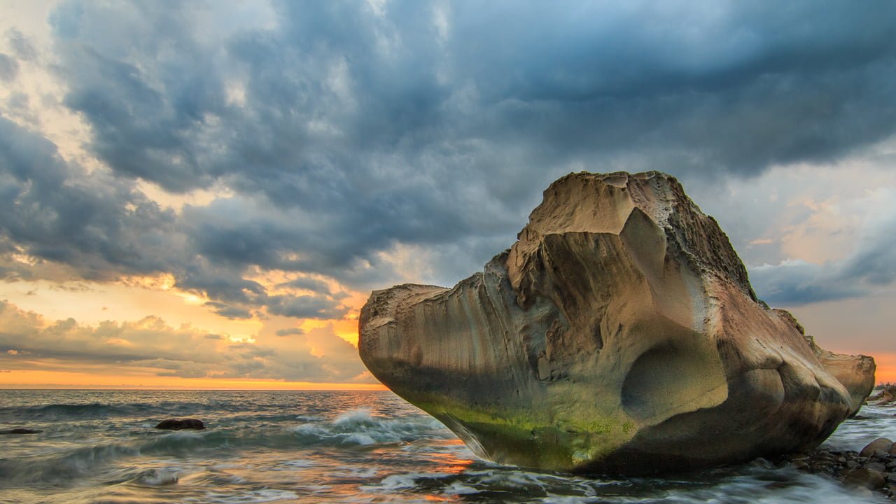 landscape photography of rock formation on body water during golden hour fangshan
