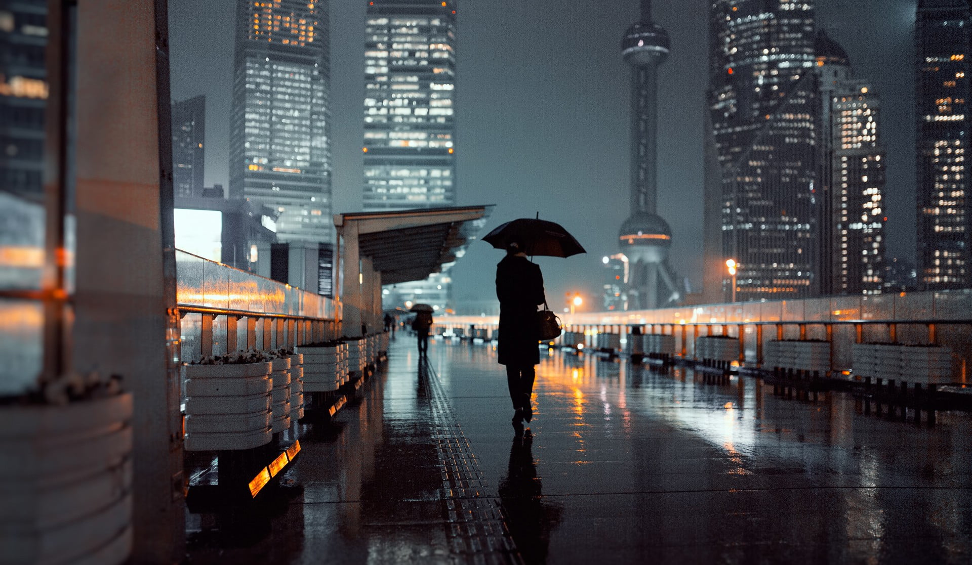 black umbrella person holding walking on street during nightime 2k
