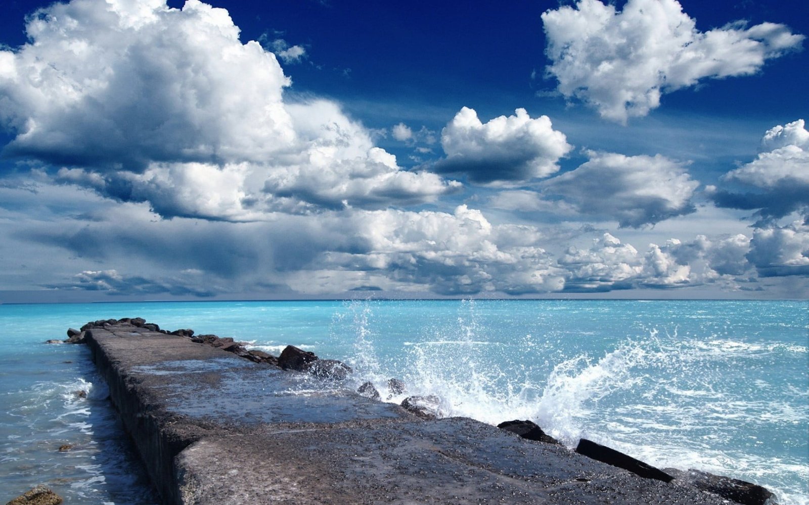 gray stone formation during daytime beach sky water sea cloud 2k