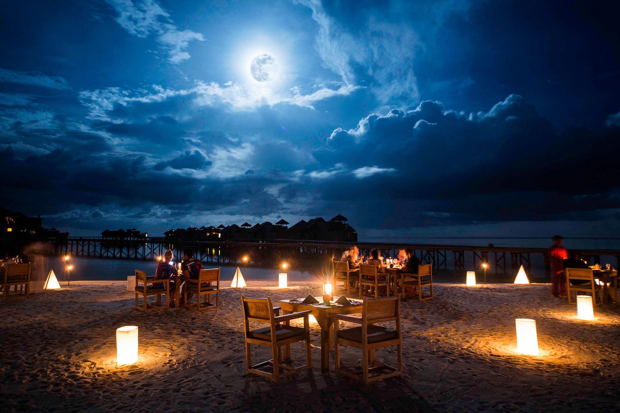 Moonlight Table for Two on a Beach brown wooden table and chair setting 2k