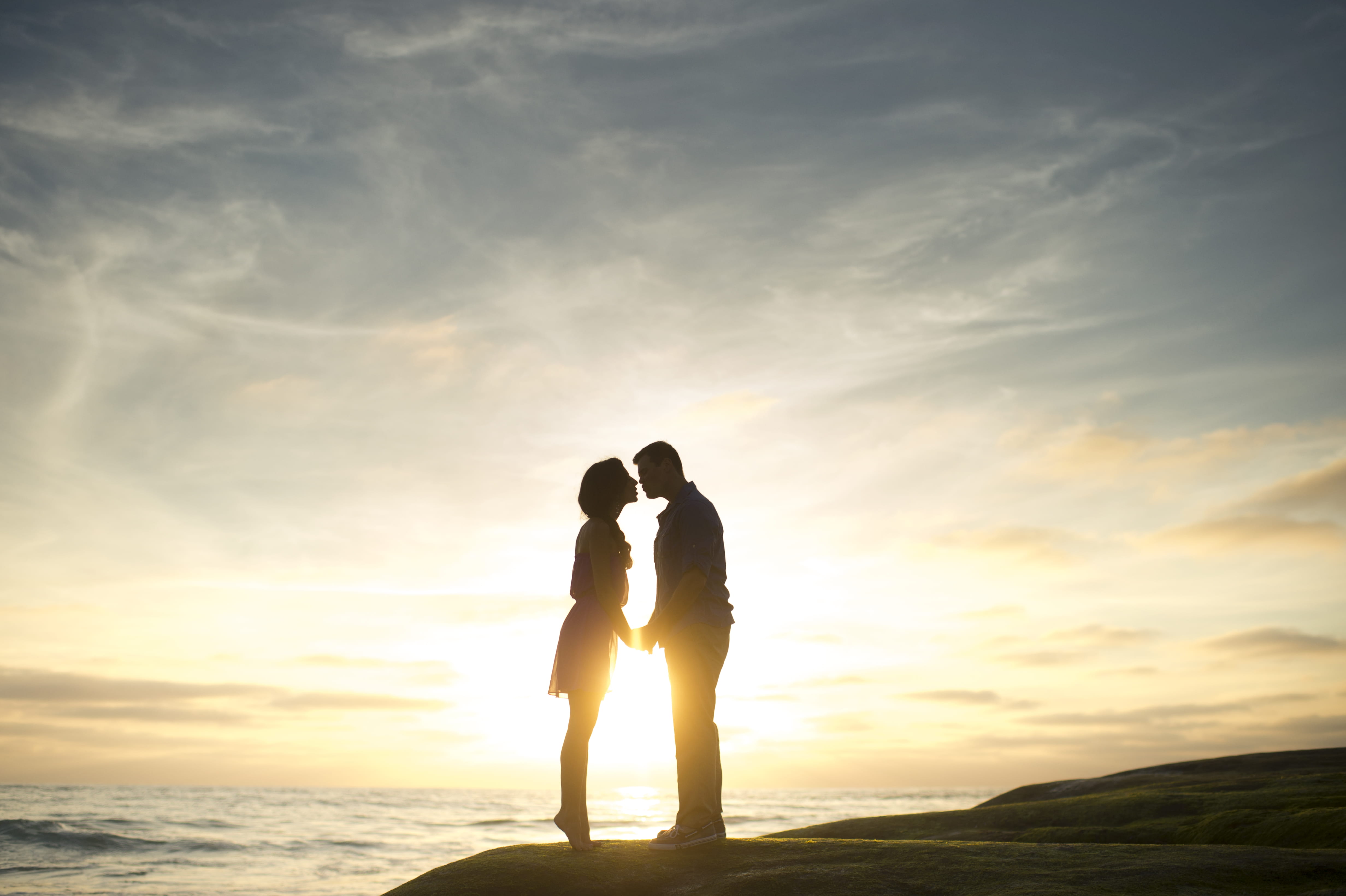 silhouette of man and woman about to kiss couple standing on beach during daytime 2k 4k 5k