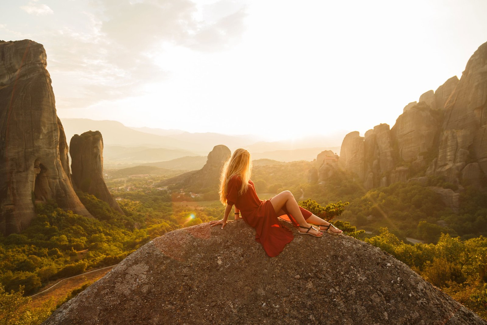woman sitting on gray rock wearing red dress formation at daytime 2k