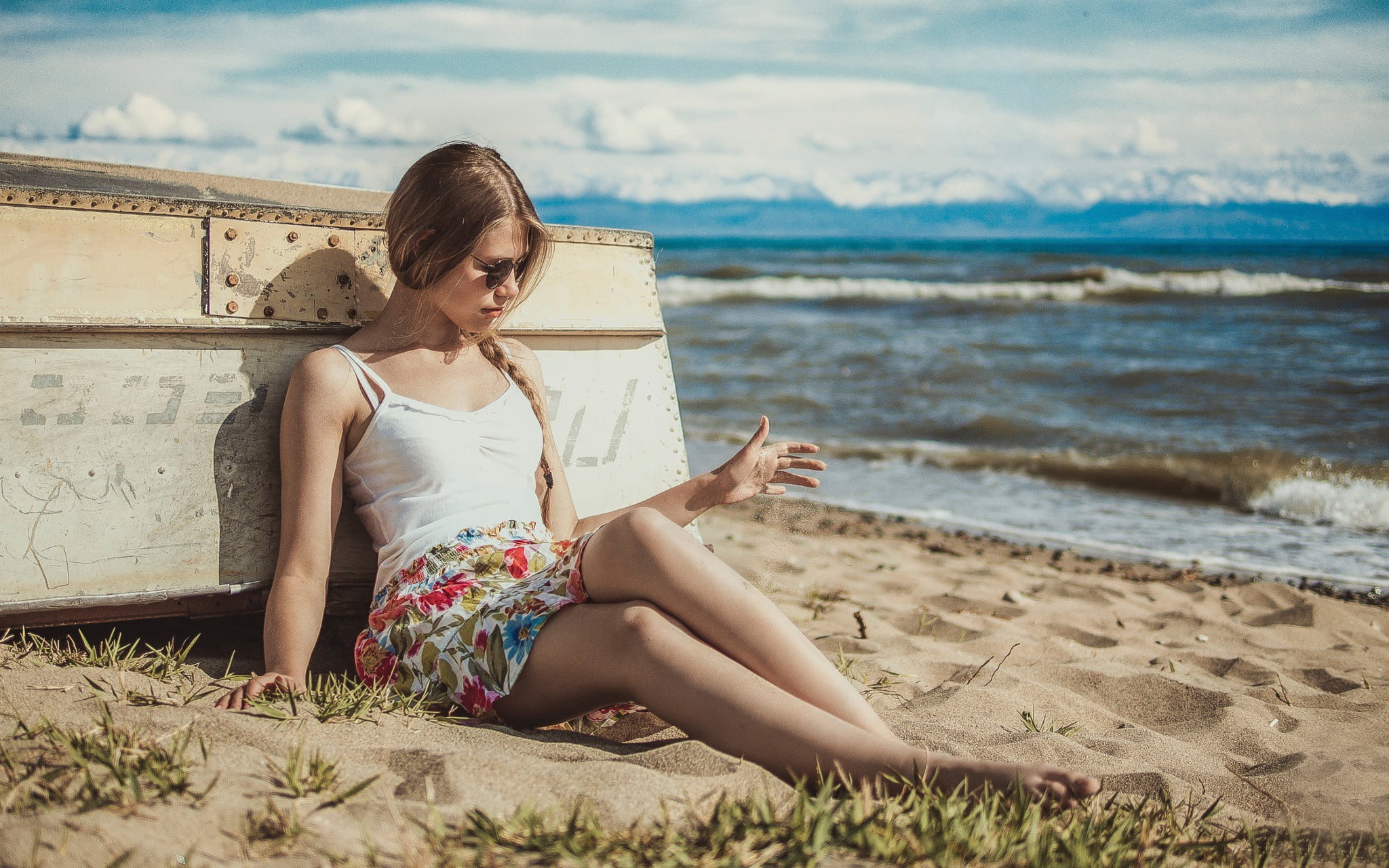 woman in white spaghetti strap top sitting on sand beach women 2k