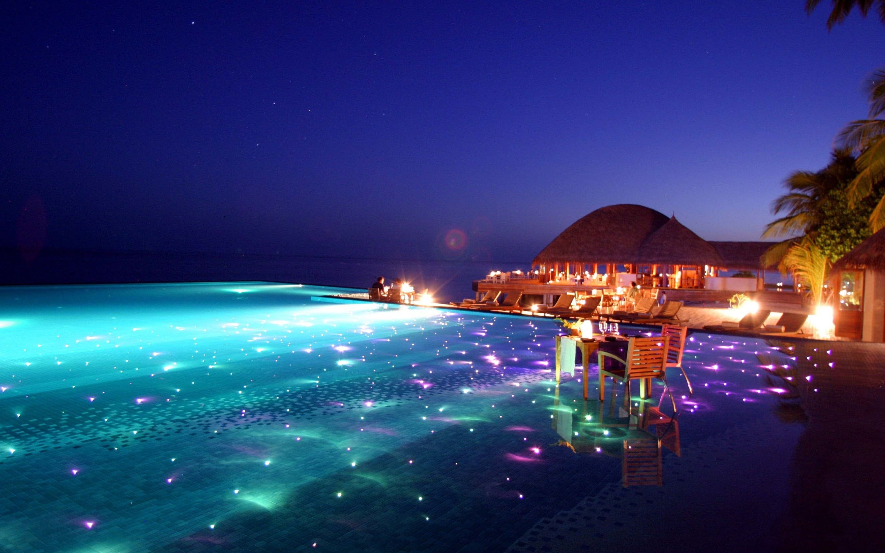 body of water and chairs beach sky Maldives glowing swimming pool 2k