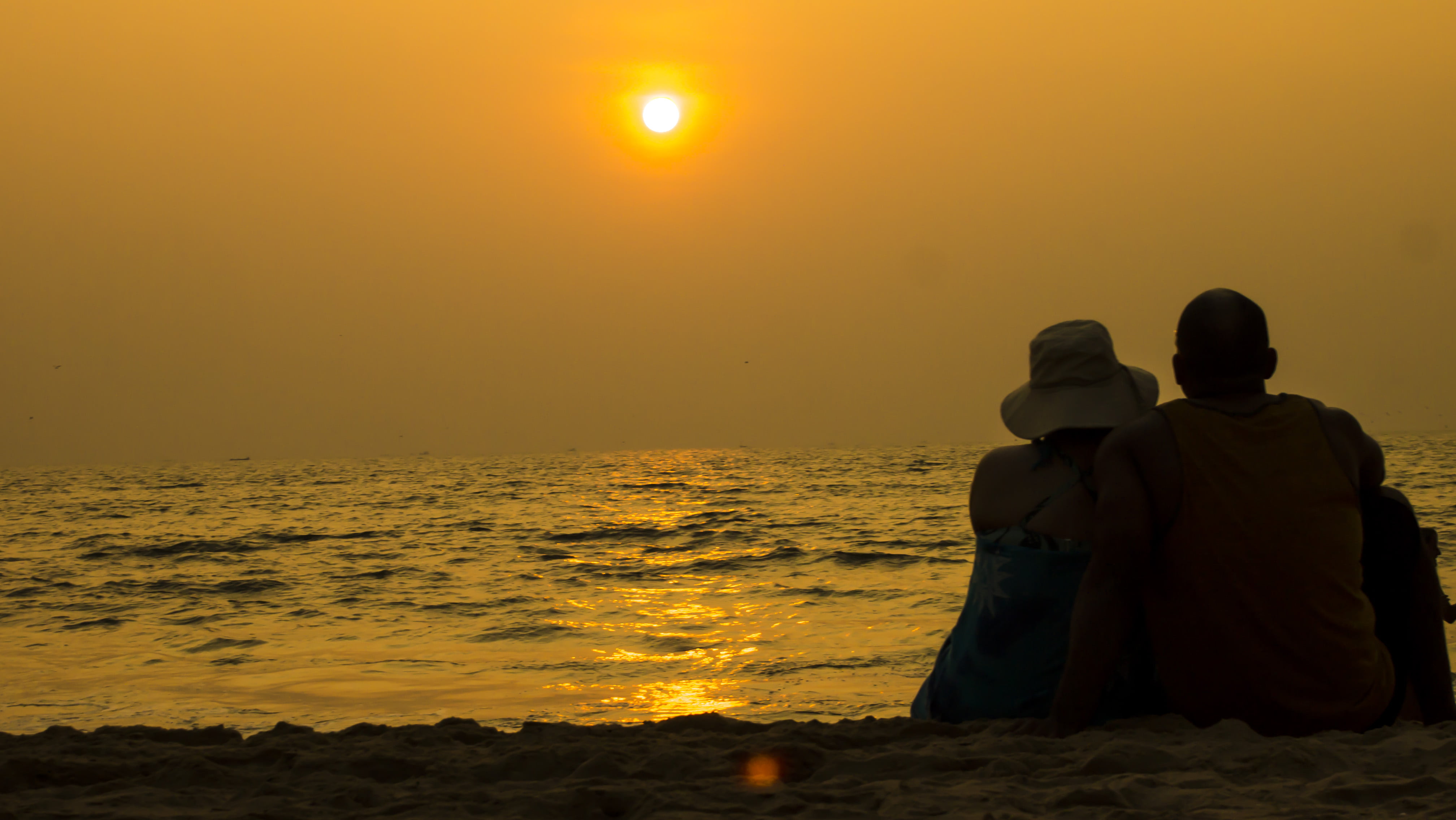 Man and woman sitting in beach side during dusk goa india 2k 4k