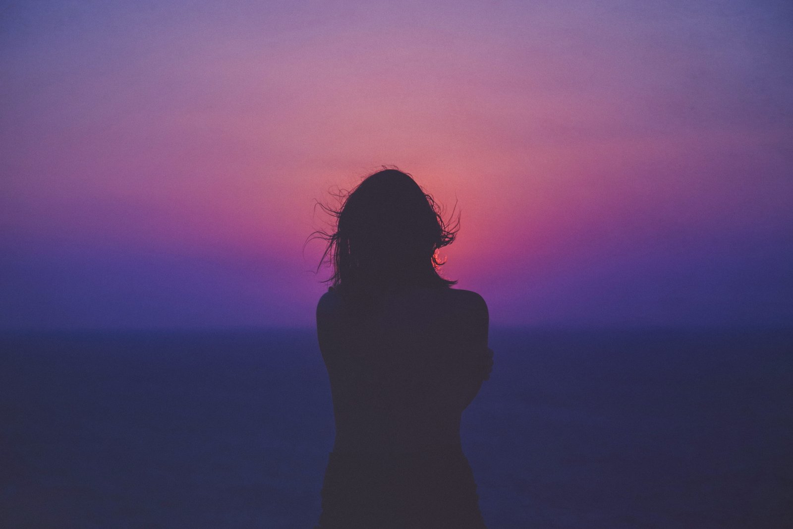 silhouette of a woman with pink and purple sky photo standing near beach 2k 4k