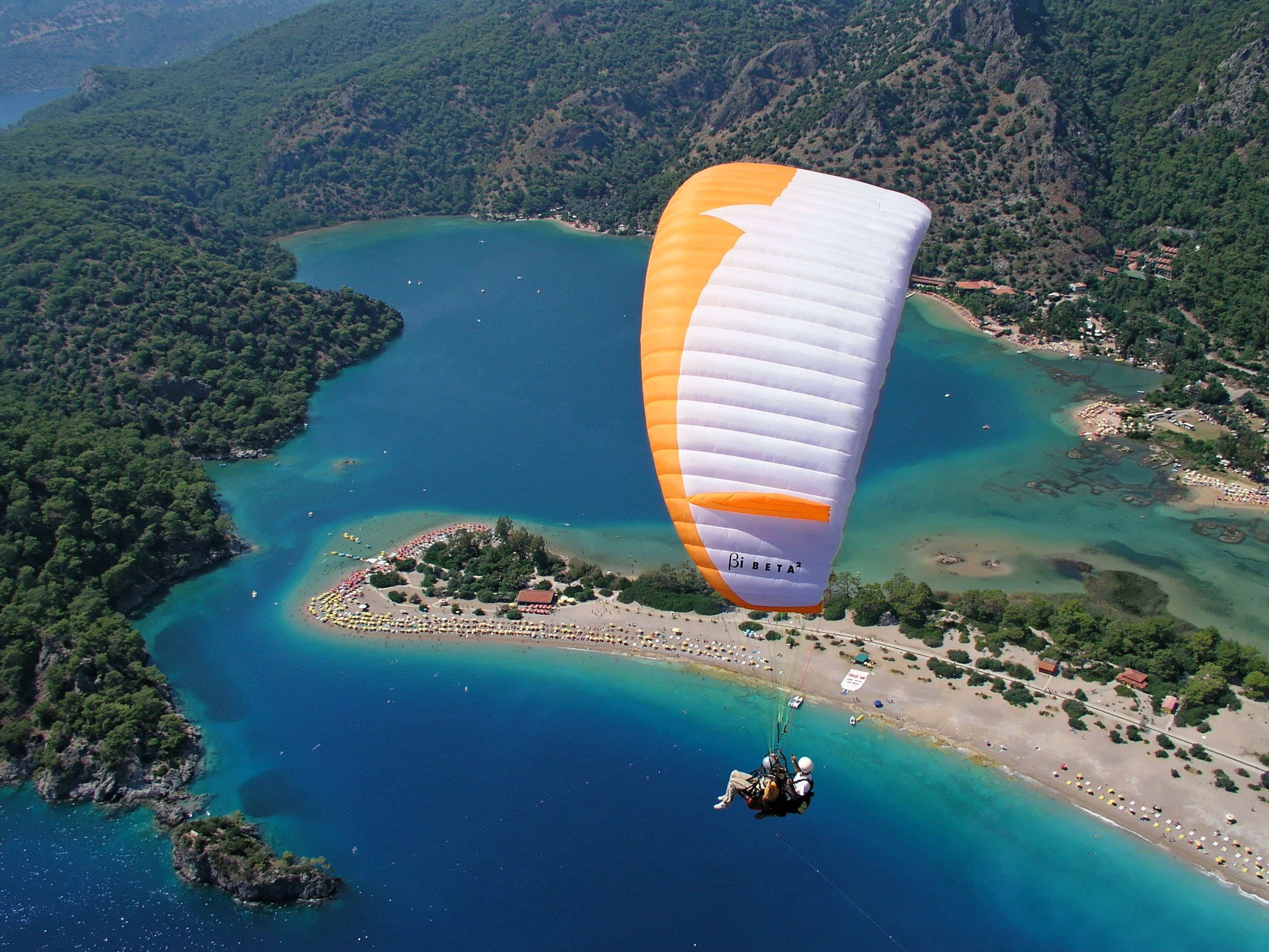 person on parachute near body of water paragliding sky air 2k