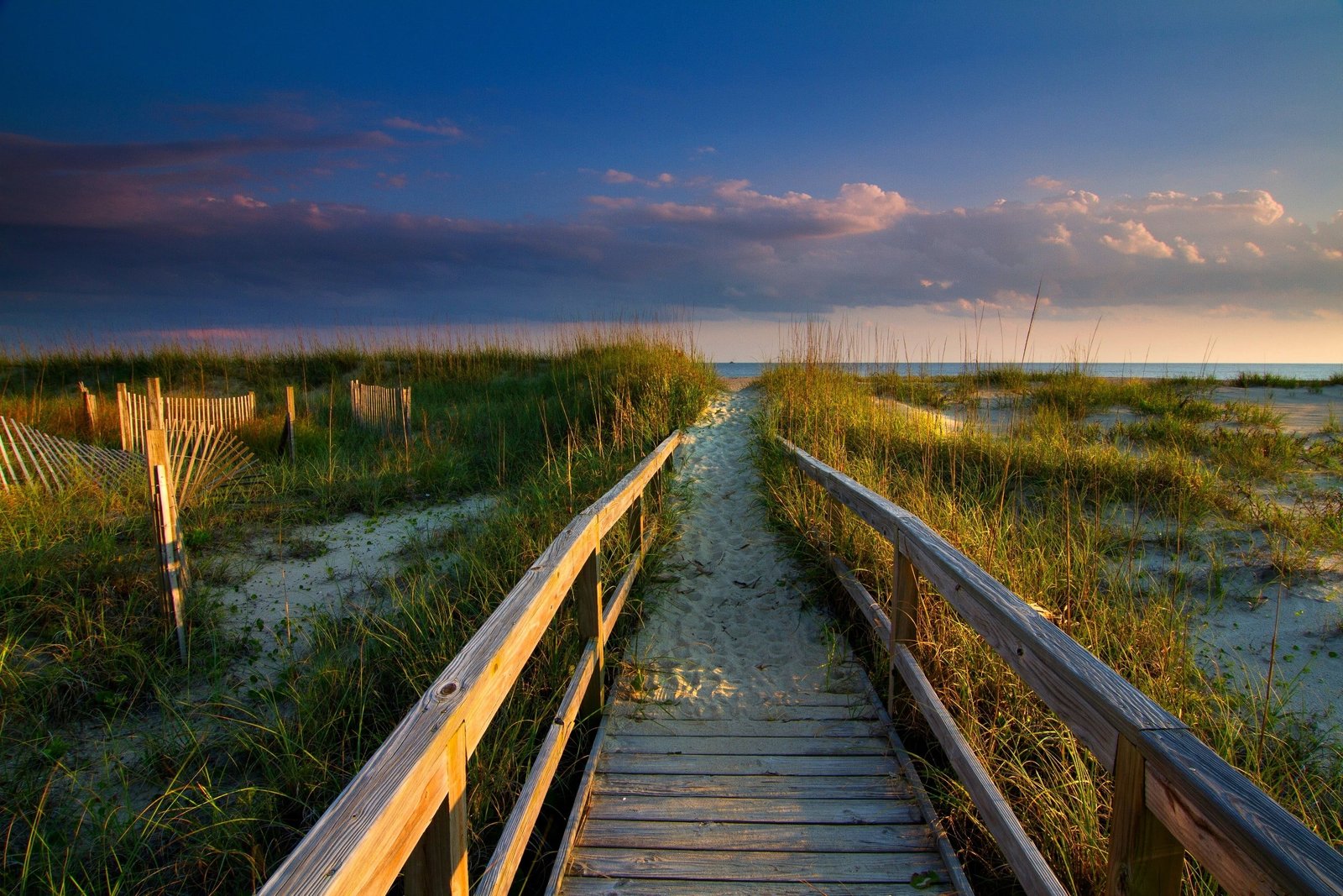 born wooden bridge walkway beach clouds grass sand sea 2k