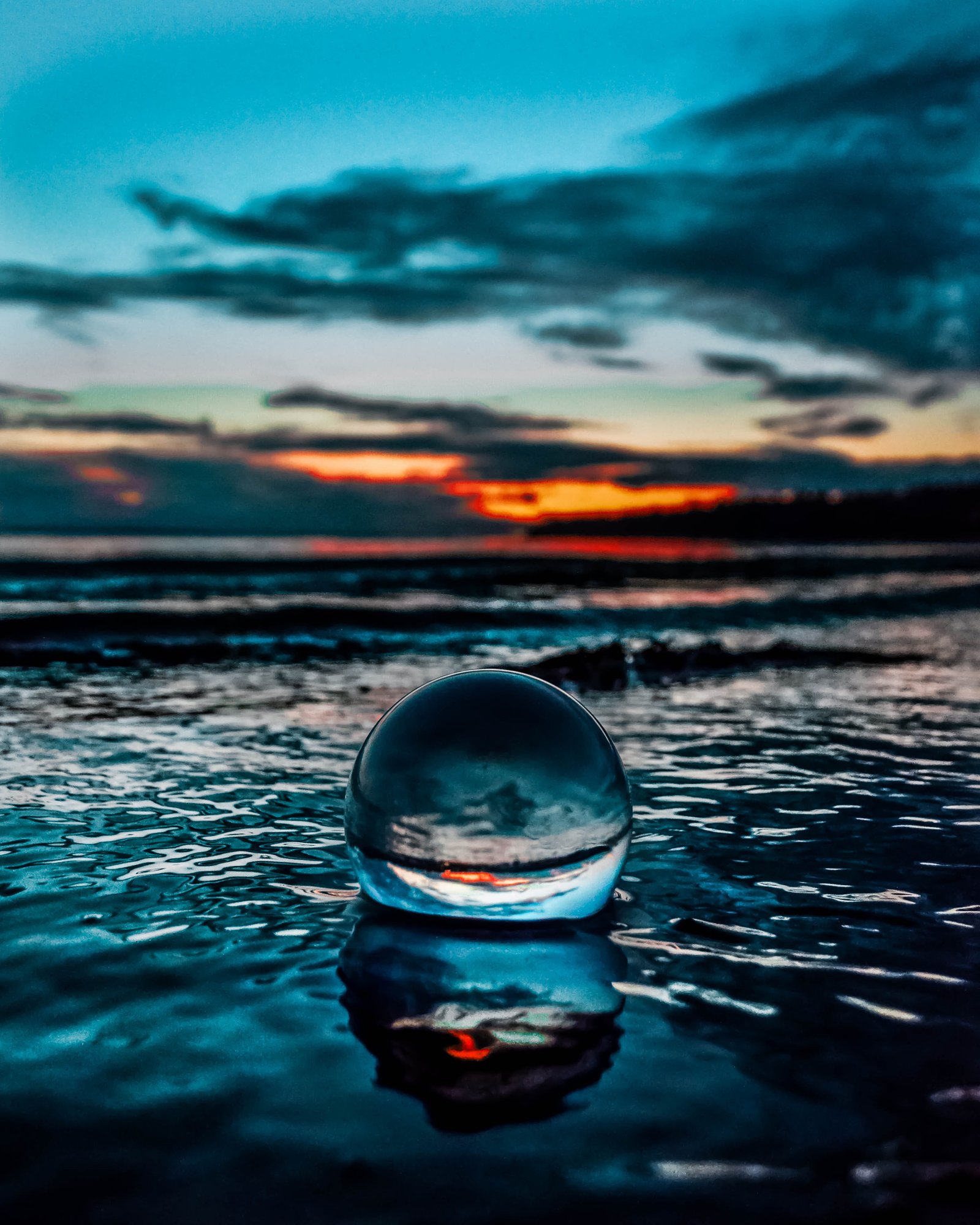 Crystal Ball on Body of Water beach clouds glass ball landscape 2k