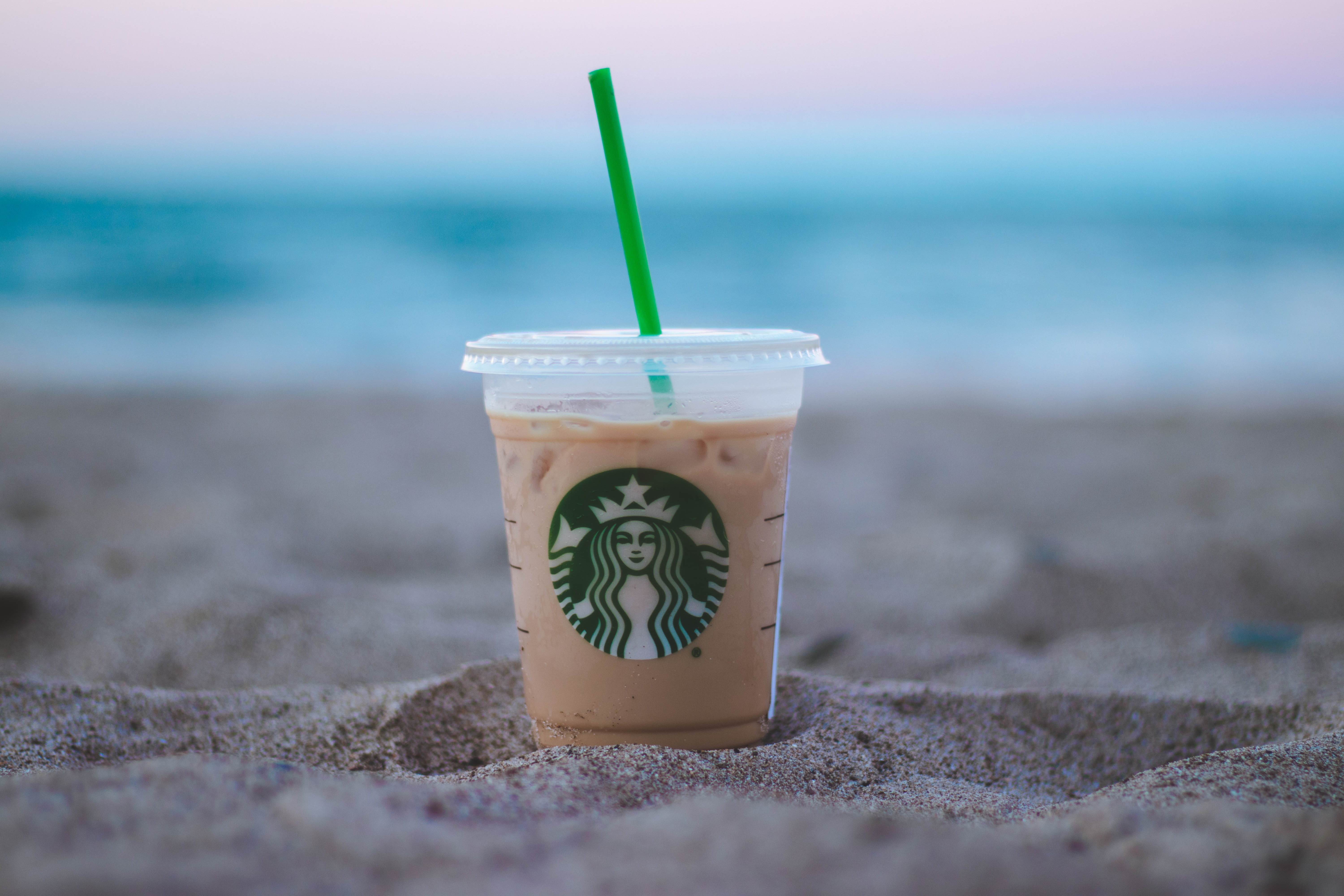shallow focus photo of clear plastic Starbucks cup on sand drink 2k 4k 5k