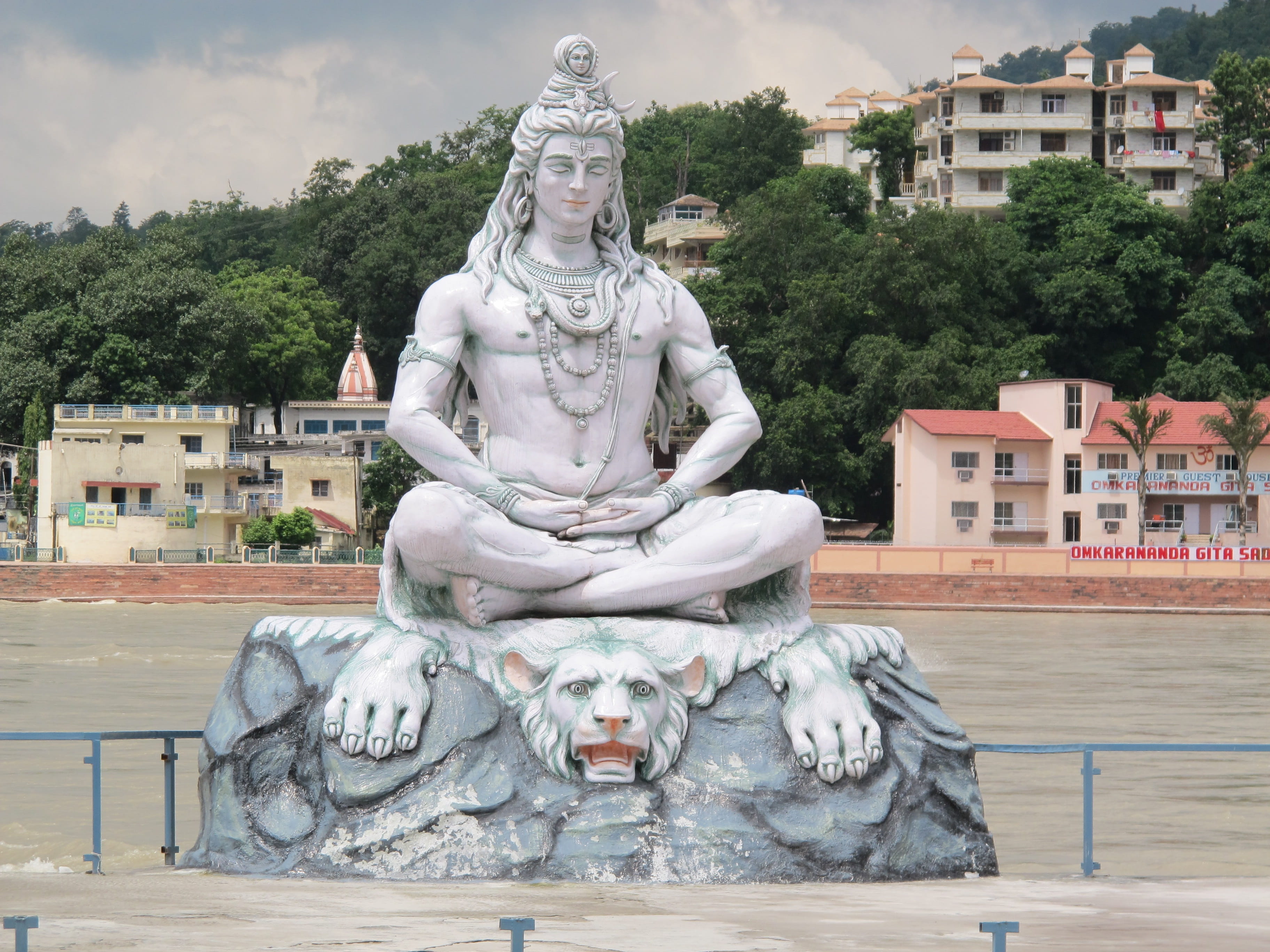 statue of Hindu Deity sitting on white tiger near river India 2k 4k