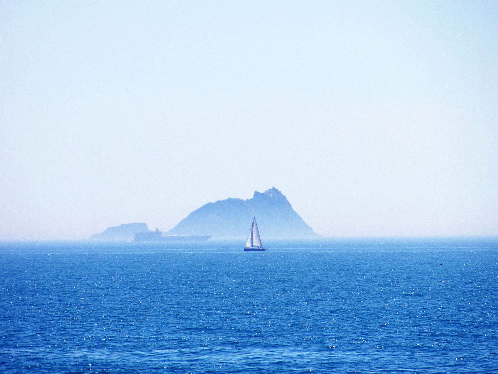 white and blue canoe on body of water near island during daytime 2k