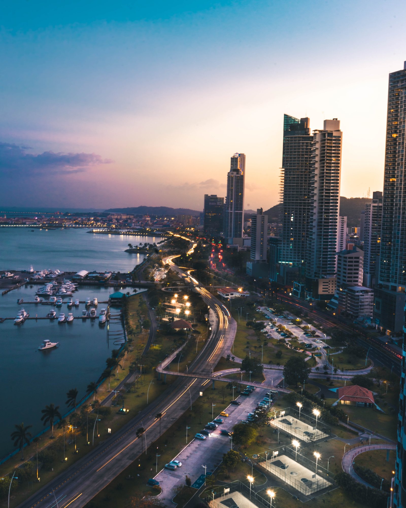 high rise buildings near body of water in distant mountain 2k 4k