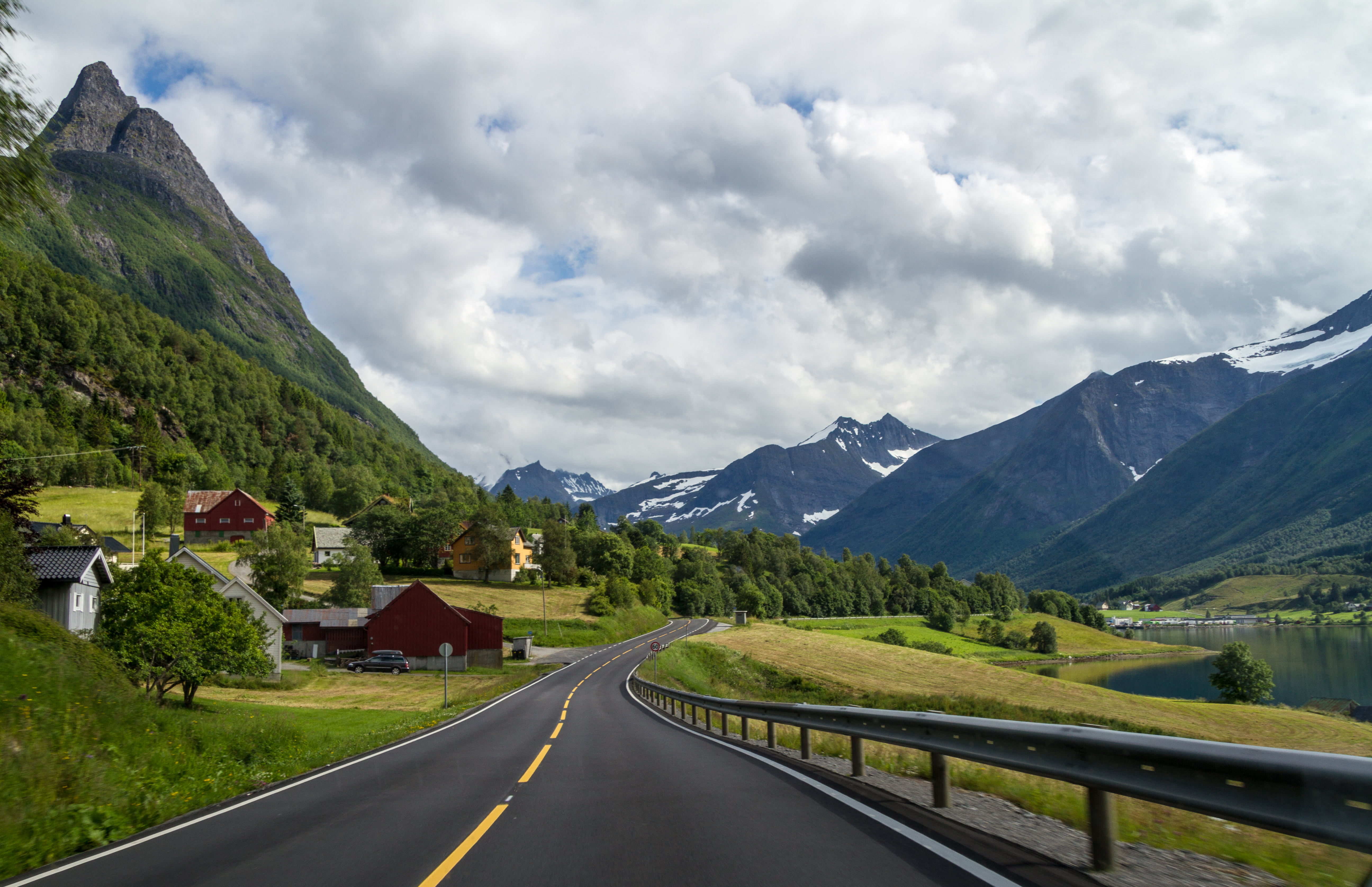 black top road across rocky mountains under white sky during daytime sykkylven 2k 4k 5k