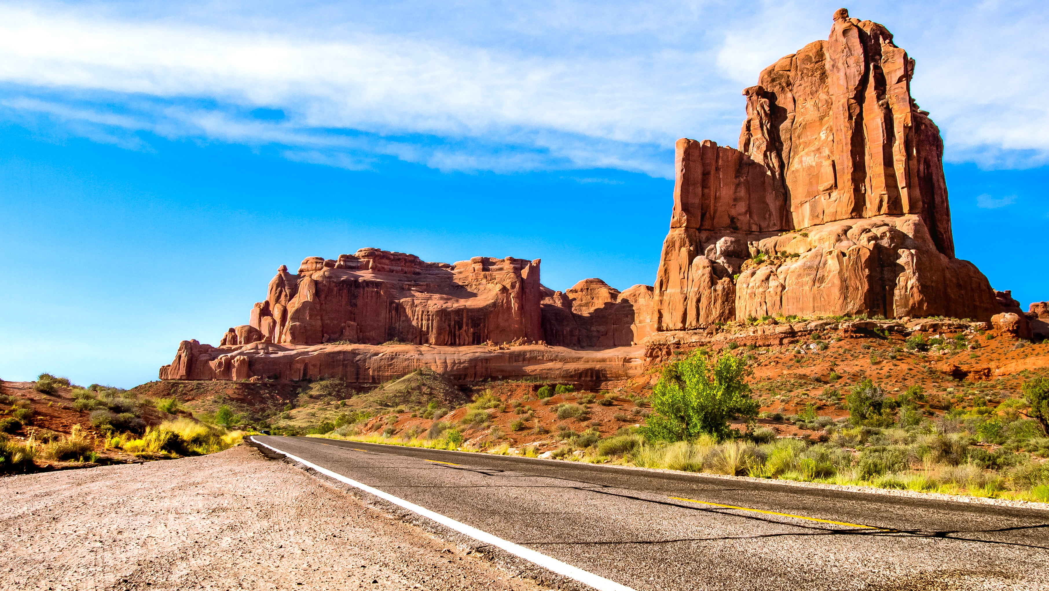 empty concrete road near rock formation Arches Scenic Drive 2k 4k
