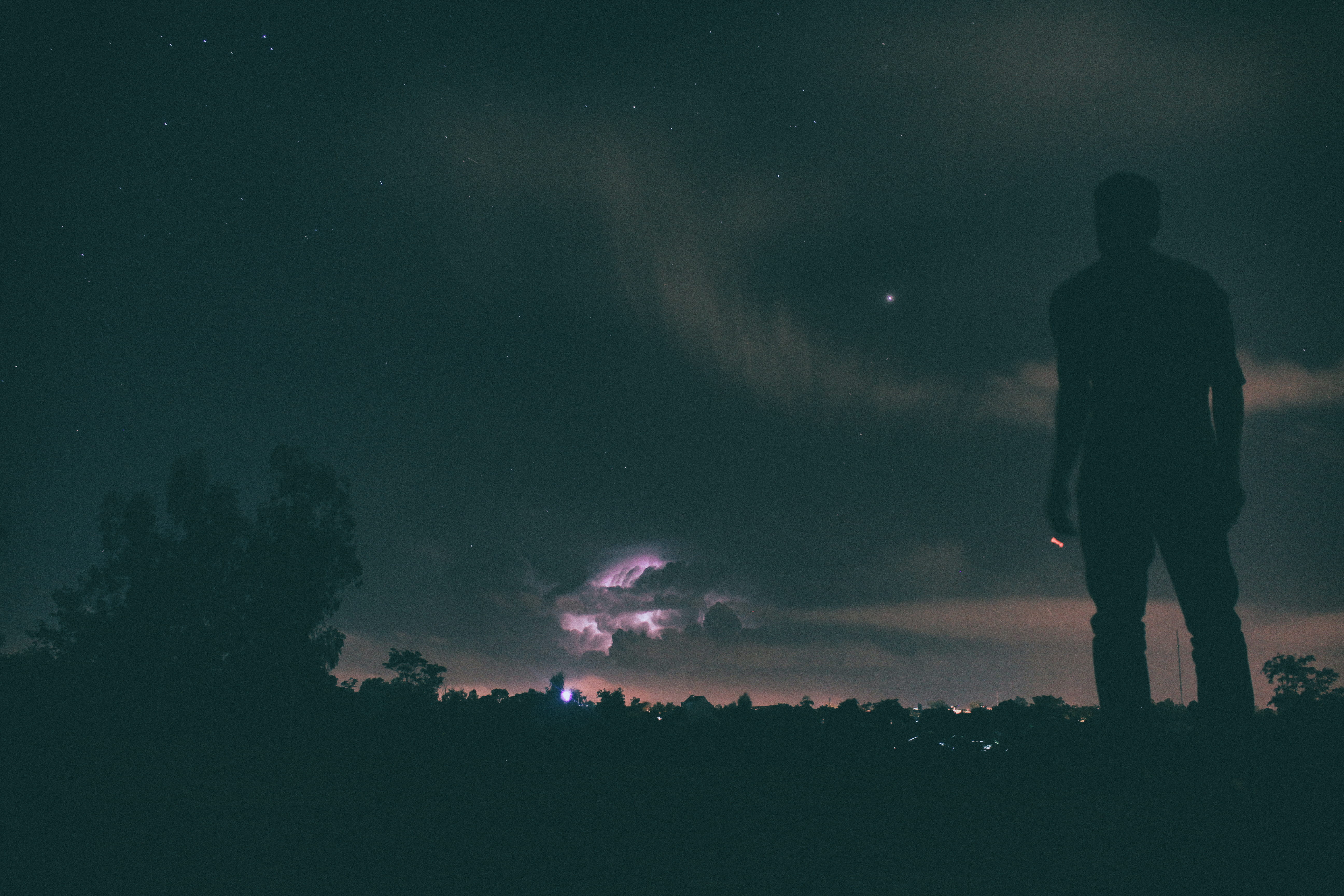 silhouette of man standing under night sky on ground looking at during nighttime 2k 4k 5k