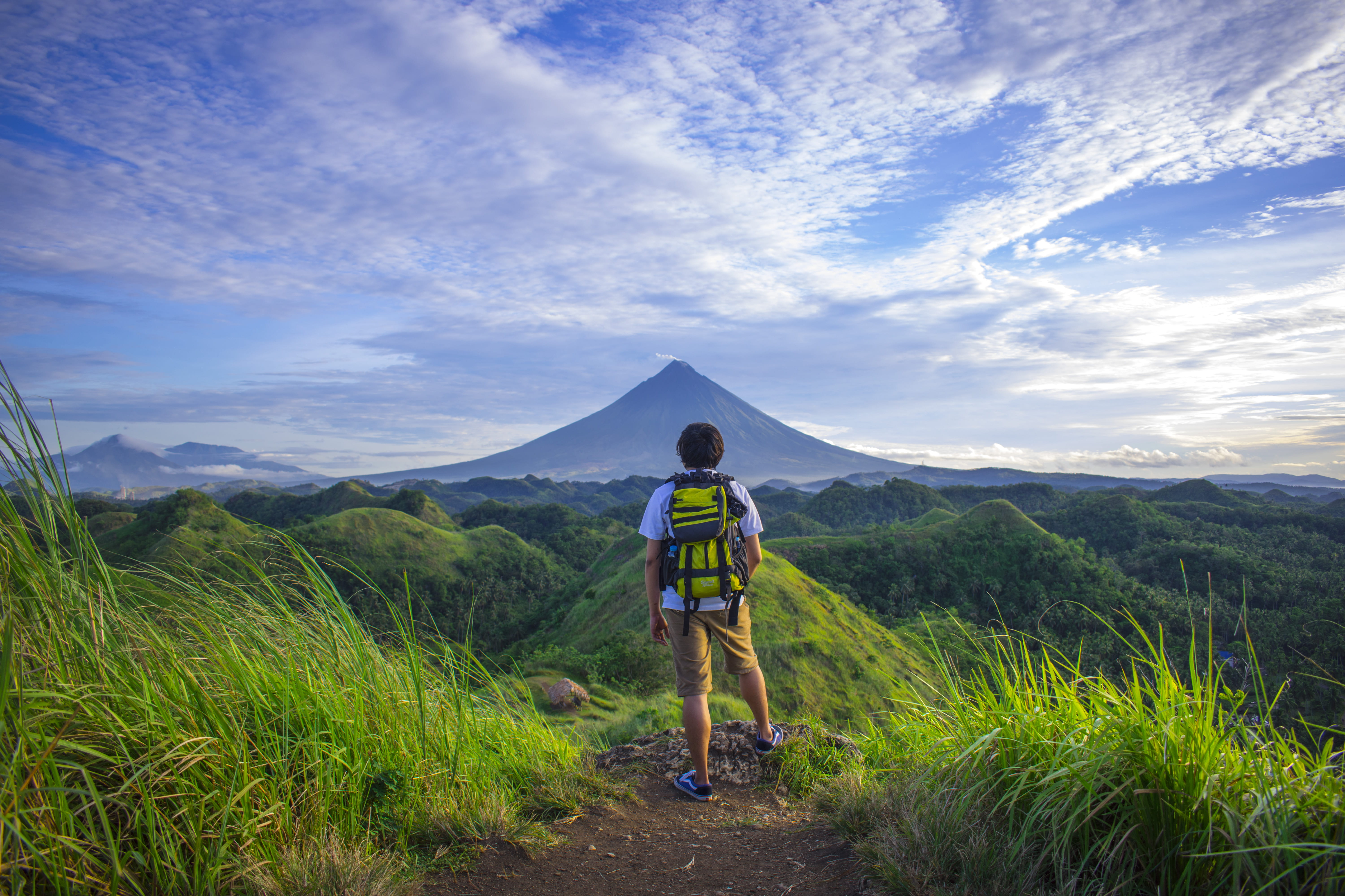 Man Wearing White Shirt Brown Shorts and Green Backpack Standing on Hill 2k 4k 5k
