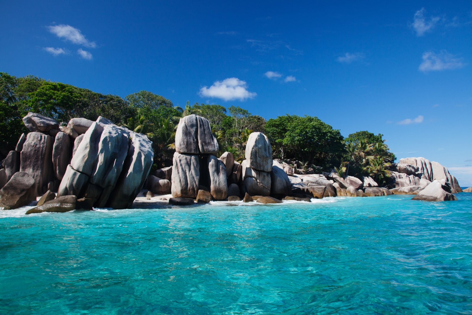view of gray stones near body the water surrounded by trees la digue seychelles 2k 4k 5k