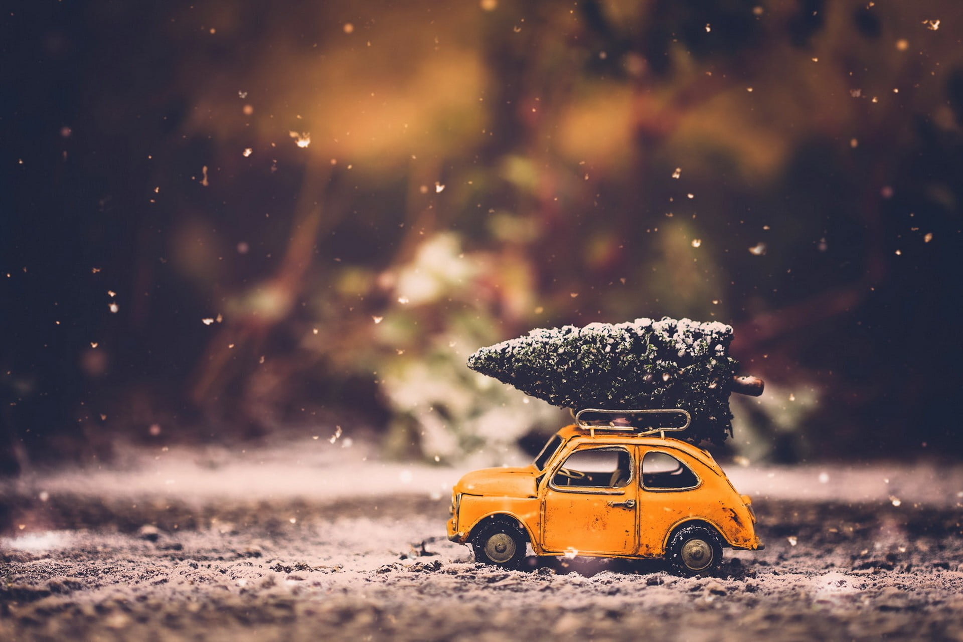 yellow car scale model orange die cast beetle with pre lit christmas tree on roof in tilt shift lens photo 2k