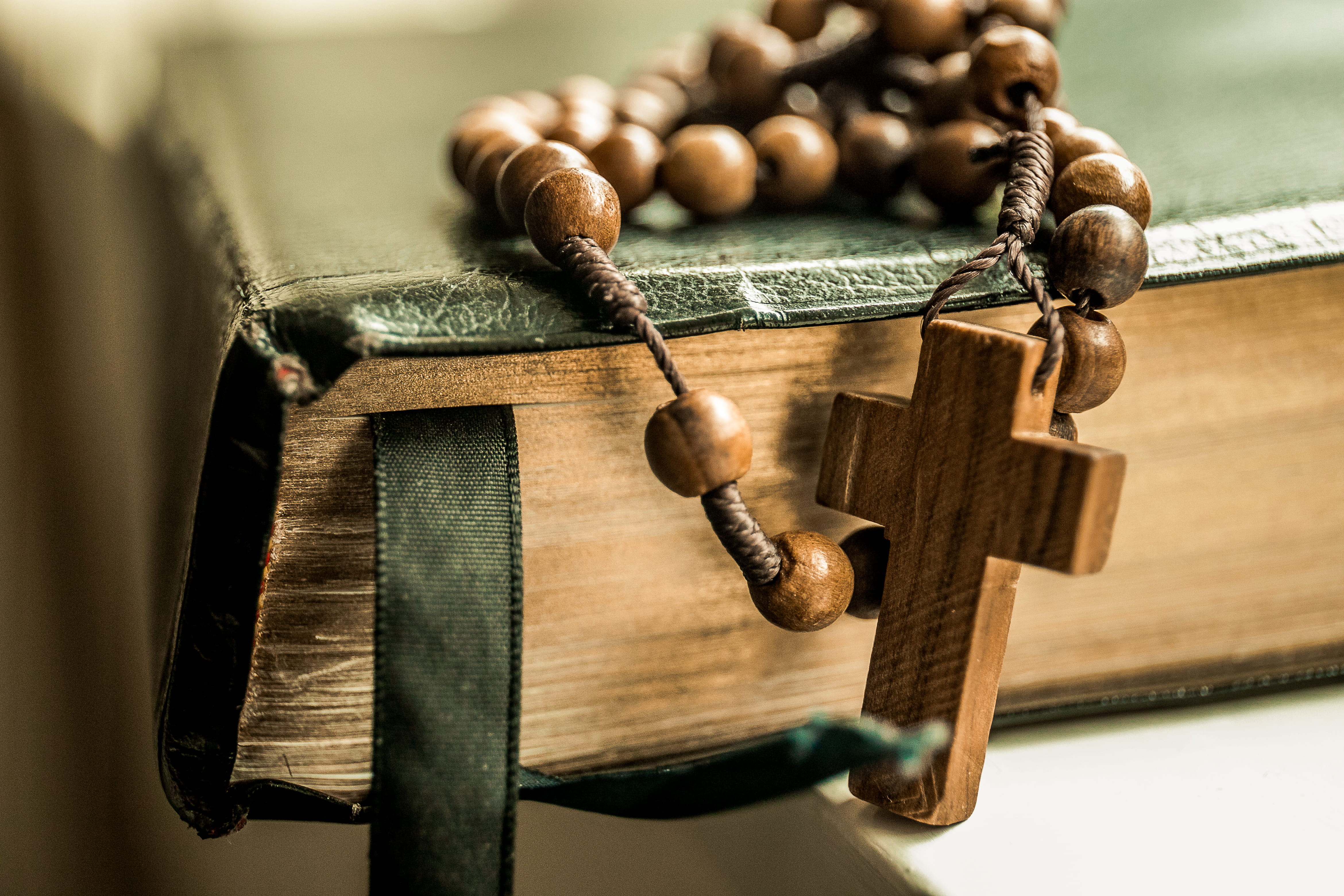 brown tesbih prayer beads on black book shallow focus photography of rosary 2k 4k 5k