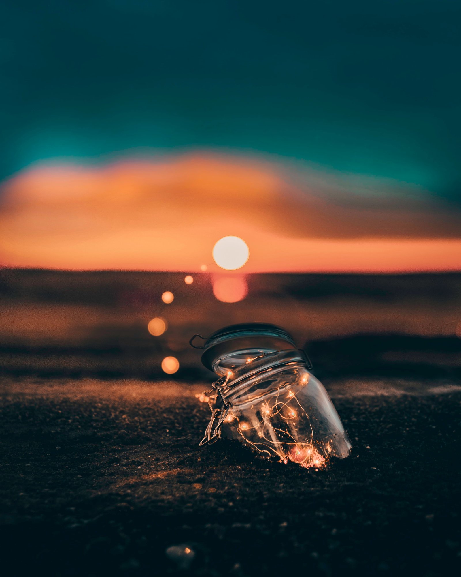 clear glass jar on sand capture the light fairy mason 2k 4k