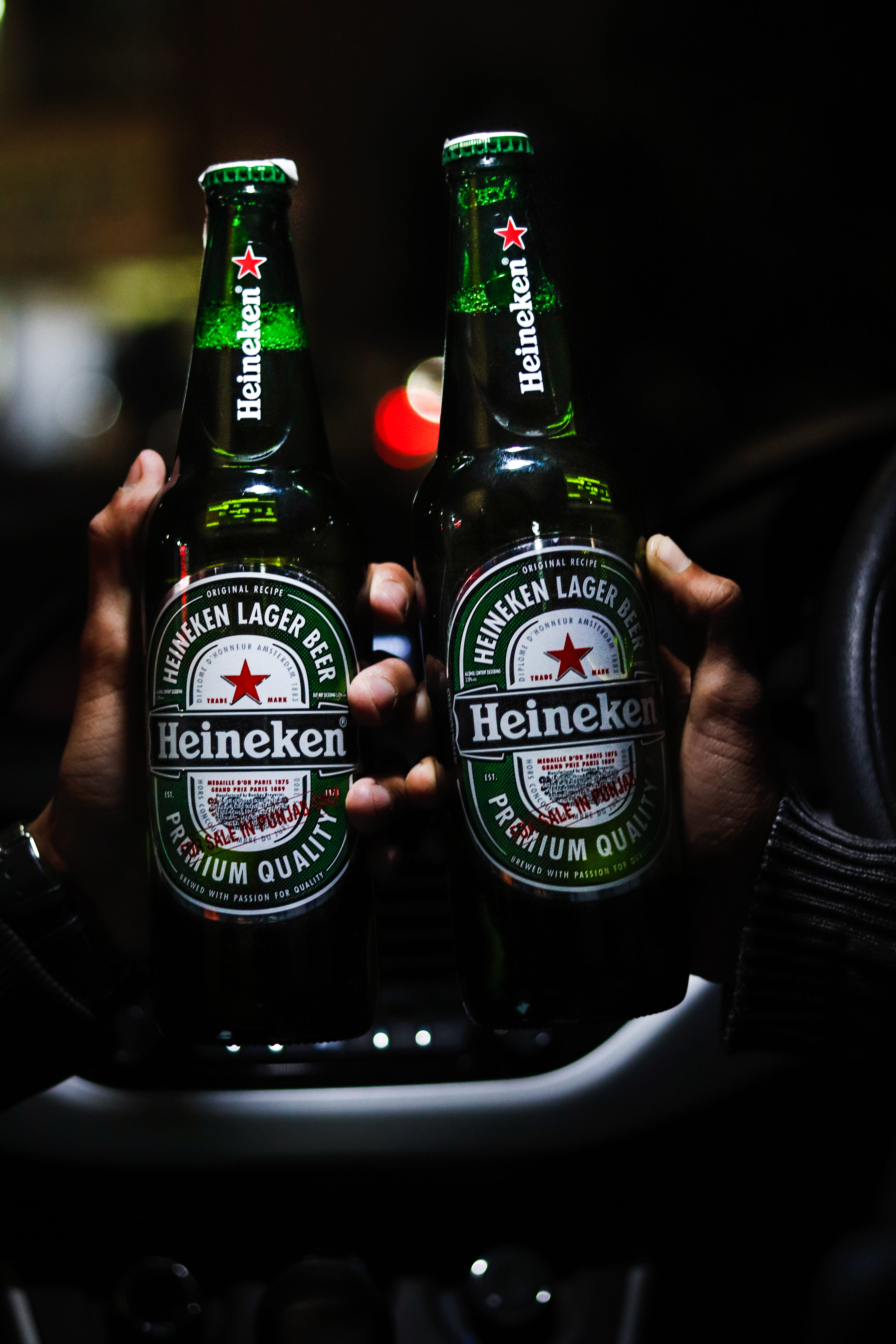 two beer bottles of heineken green beverages car city 2k 4k