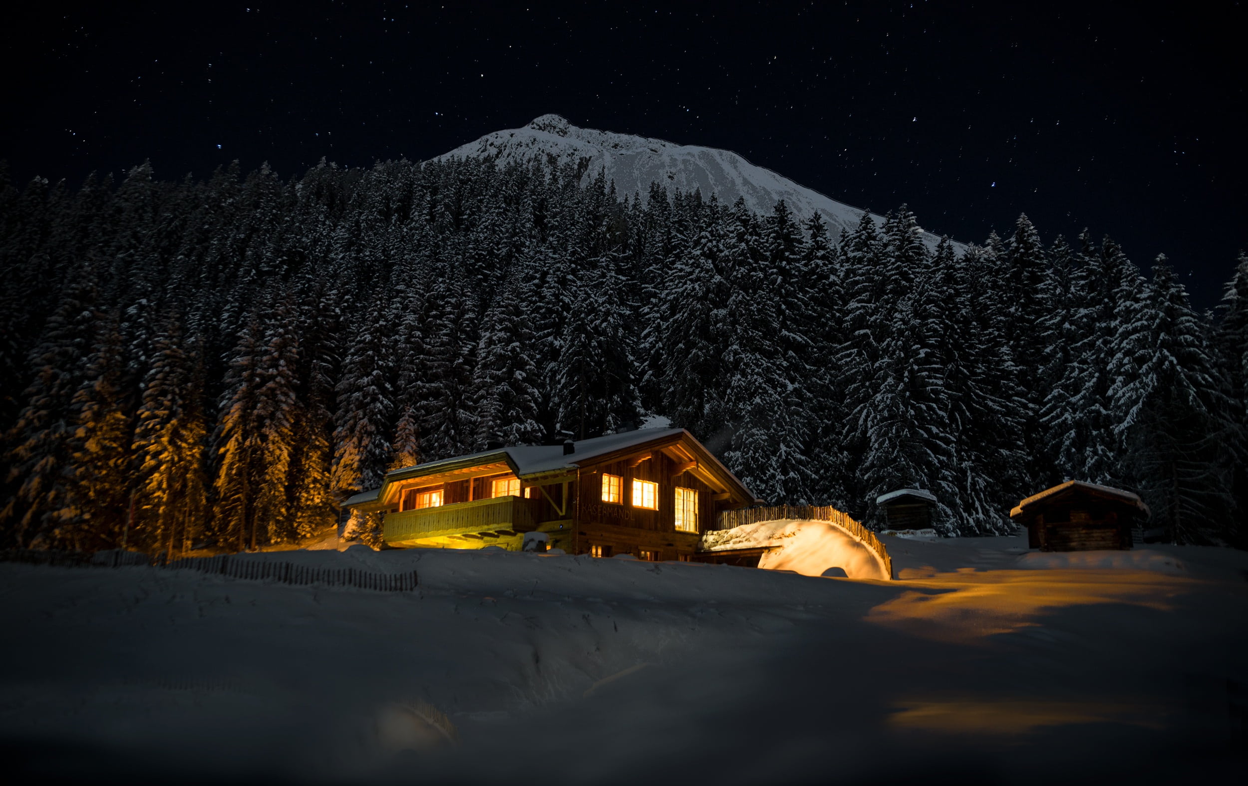 brown wooden house near trees covered with snow night star 2k