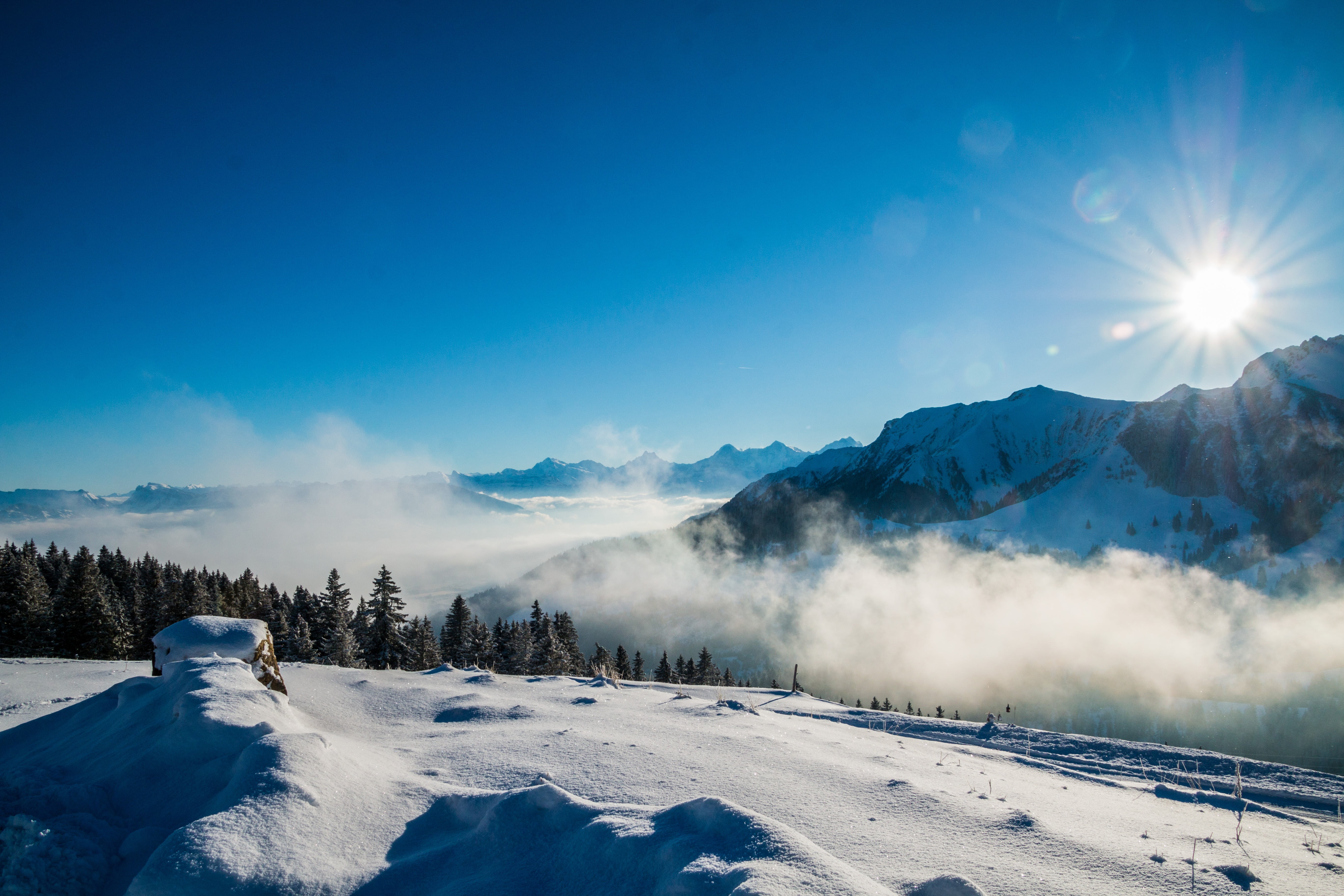 snow covered mountains during daytime winter sky sun fog 2k 4k 5k