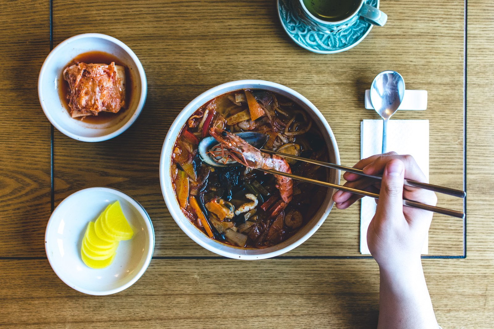 Eating Korean seafood stew hands soup top view wood chopsticks 2k 4k 5k